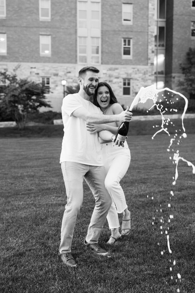 couple popping champagne on Boston College Campus