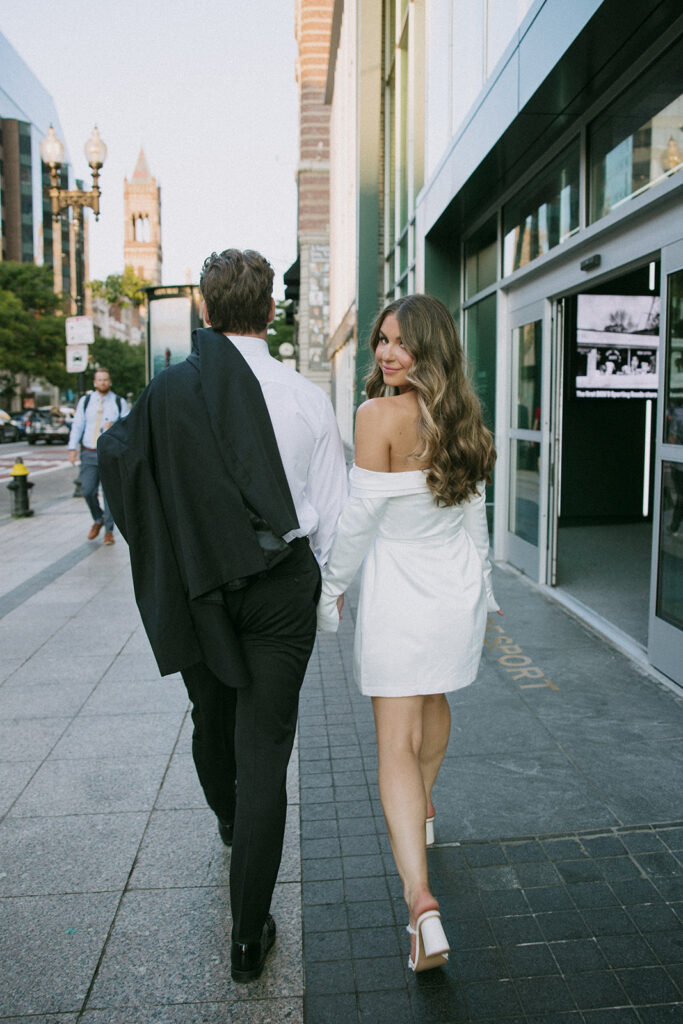 bride looking back as couple walks along street