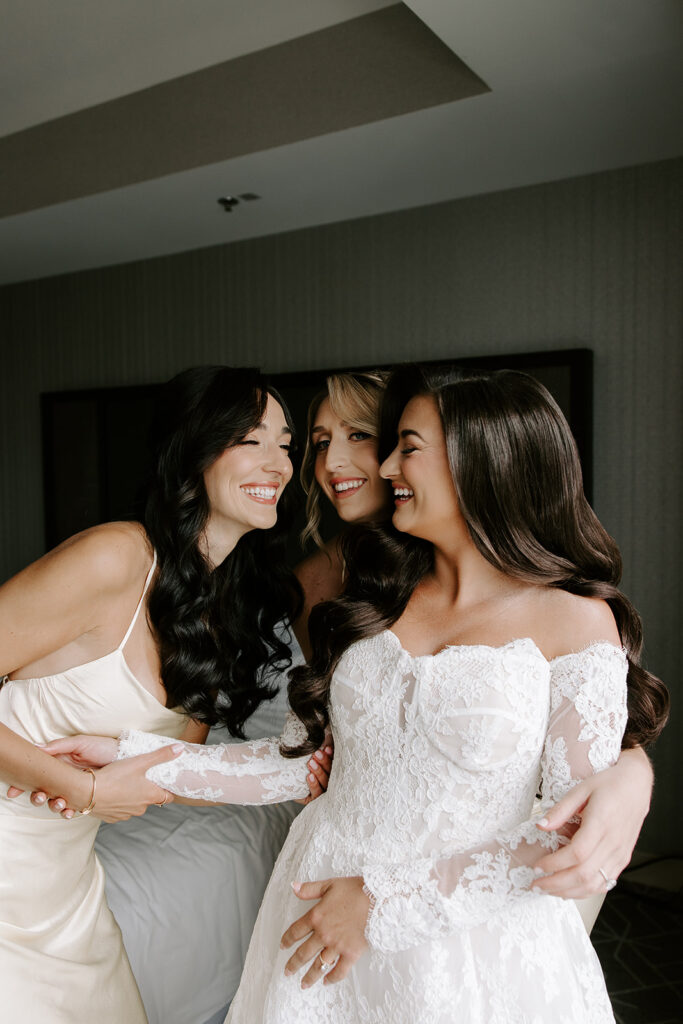 Bridesmaids helping bride into her Pnina Tornai wedding dress