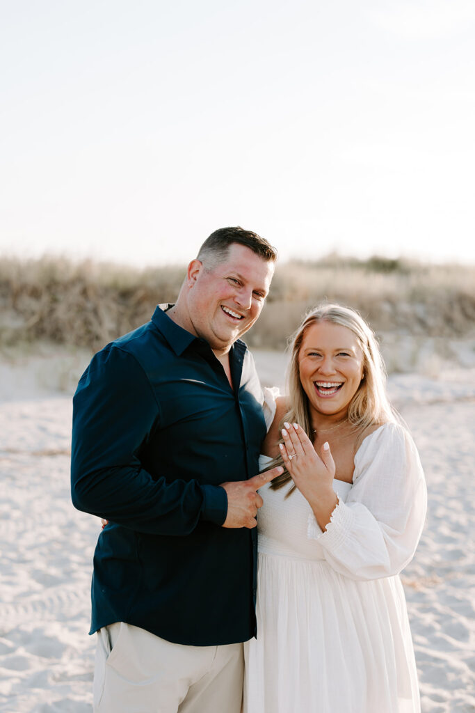 Couple laughing in casual outfits on the beach