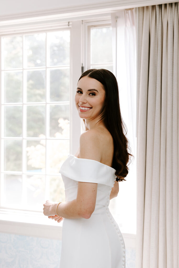 bride looking out window while getting ready