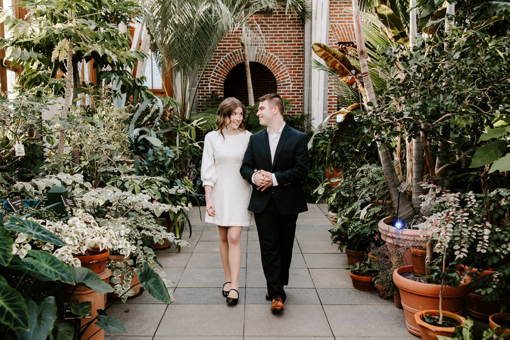 Couple walking hand-in-hand through greenhouse at New England Botanic Garden