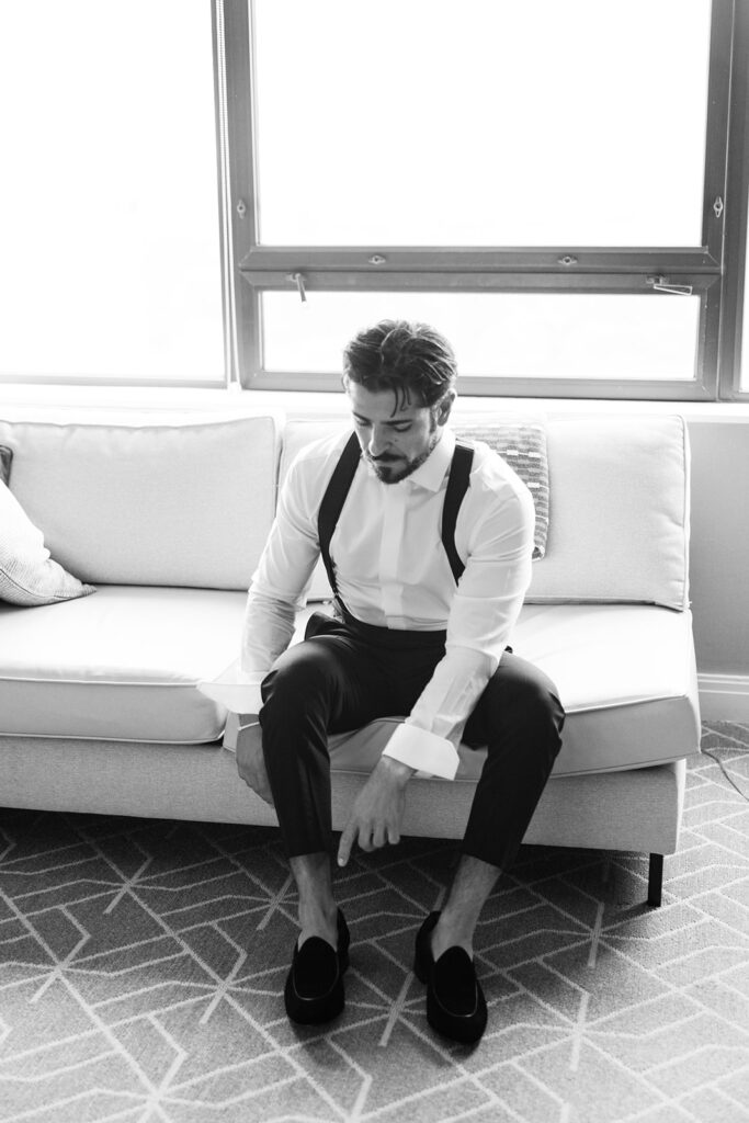 groom putting dress shoes on