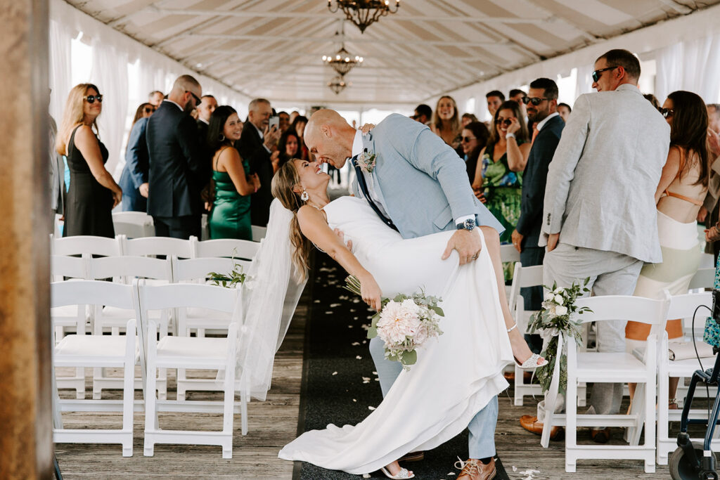 Bride and groom kissing at Regatta Place Newport harbor at night