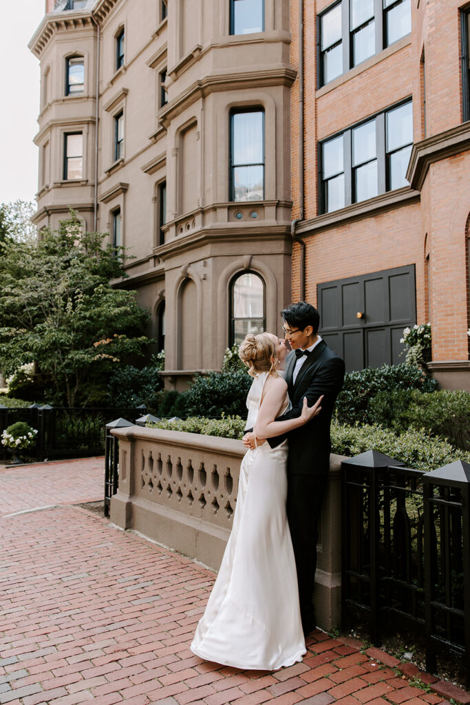 Couple kissing in front of a Boston Back Bay brownstone during their Commonwealth Avenue elopement portraits
